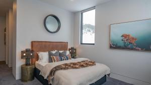 a bedroom with a bed and a mirror on the wall at Peak Chalet in Mount Hotham