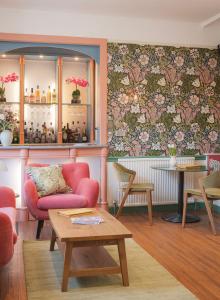 バースにあるHarington's Boutique Hotelの椅子とテーブルがあり、壁に花が飾られた部屋