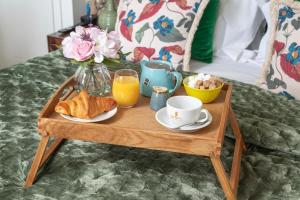 a wooden tray with breakfast foods on a bed at Harington's Boutique Hotel in Bath
