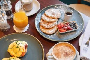 a table topped with plates of pancakes and a cup of coffee at Harington's Boutique Hotel in Bath +80 photos