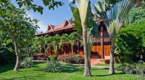 a house with palm trees in front of it at Angkor Village Resort & Spa in Siem Reap