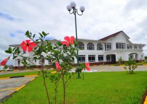 a large white building with red flowers in front of it at Greenpark Sundowner in Athi River