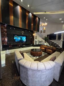 a living room with a large couch and a tv at D5 future homes hotel & apartment in Benin City