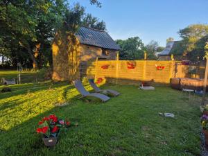 a yard with two benches and a yellow fence at Le petit campîng de Vallye in Maxent