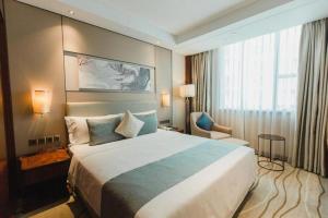 a hotel room with a large bed and a window at Grand Soluxe Zhongyou Hotel Shenzhen in Shenzhen +215 photos