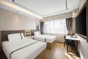 سرير أو أسرّة في غرفة في GreenTree Inn Shenyang Tiexi Huaxiang Road Metro Station Express Hotel +140 صورة