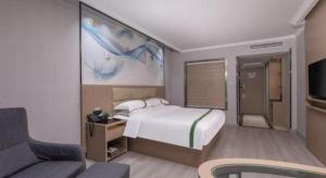 a hotel room with a bed and a couch at GreenTree Inn JiangSu Changzhou Lijia Town Wujin Road Business Hotel in Changzhou +192 photos