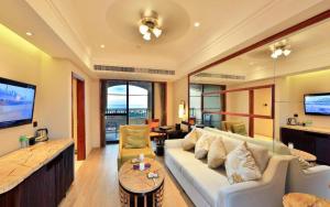 a living room with a white couch and a tv at Hainan Yatai Hot Spring Hotel in Haikou