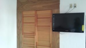 a flat screen tv hanging on a wall next to a closet at Hotel Real de Cuautla in Cuautla Morelos