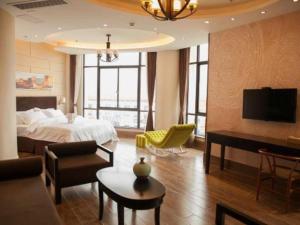 a hotel room with a bed and a living room at Jinjiang Metropolo Hotel - Liyang Tianmu Lake in Liyang