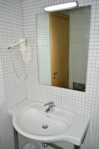 a white bathroom with a sink and a mirror at Marnin Apartments in Rhodes Town