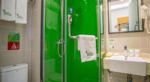 une salle de bain verte avec un lavabo et une douche dans l'établissement Vatica Beijing Miyun West Guoyuan Street Hotel, à Xiaotangzhuang 125 autres photos