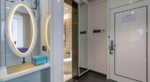 ein Badezimmer mit einem Spiegel und eine Tür mit einem Waschbecken in der Unterkunft Xana Hotelle· Tianjin Railway Station Jinwan Square Binjiang Avenue in Tianjin + 148 Fotos