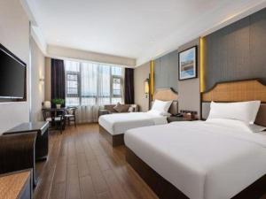 ein Hotelzimmer mit zwei Betten und einem Fernseher in der Unterkunft Metropolo Hotel YunNan Shangri-la Karma Dan Songzanlin Temple in Shangri-La + 60 Fotos