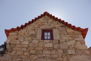 um edifício com uma janela numa parede de pedra em Casas da Fonte - Serra da Estrela em Seia