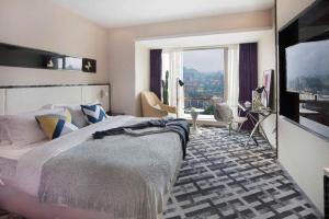 a bedroom with a large bed and a large window at GreenTree Alliance Hotel Guiyang Huaguo Community Central Business Zone in Guiyang