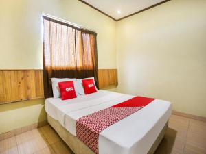 a bedroom with a large bed with red pillows at OYO 3396 Sun Garden Resort in Pablengan