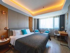 a hotel room with a large bed and a desk at Yitel Collection Shenyang North Railway Station Metro Station in Shenyang +143 photos