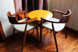 einen Holztisch mit 2 Stühlen und Holzboden in der Unterkunft Jun Hotel Guangxi Wuzhou Changzhou District Fengye Garden in Wuzhou + 86 Fotos