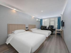 a room with three beds and a desk with a computer at GreenTree Inn Hotel - Nantong Hongming Plaza in Nantong +234 photos