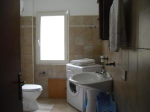 a bathroom with a sink and a washing machine at Appartamento MareMontagna in Cardedu