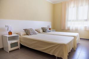 1 dormitorio con 2 camas y ventana en RVHotels Apartamentos El Quijote en L'Estartit