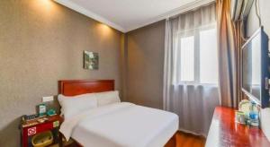 a bedroom with a white bed and a window at GreenTree Inn Shanghai South Railway Station Xujiahui Stadium Subway Station Shell Hotel in Shanghai