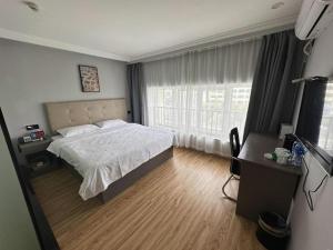 a bedroom with a bed and a large window at GreenTree Inn Huaian Lianshui Jindi International Garden Business Hotel in Lianshui
