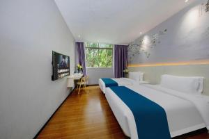 a hotel room with two beds and a window at Wenxing Hotel Guangzhou Nanfang Hospital Branch in Guangzhou