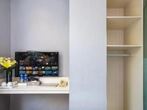 a room with a desk with a computer on a shelf at Wenxing Hotel Guangzhou Nanfang Hospital Branch in Guangzhou