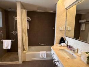 上海Argyle International Airport Hotel Shanghai的带浴缸、水槽和淋浴的浴室