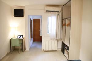 a room with a desk and a table and a window at Parrots Sitges Hotel in Sitges