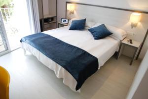 a hotel room with a bed and two lamps at Parrots Sitges Hotel in Sitges