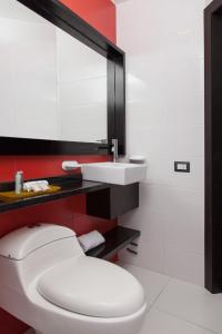 a bathroom with a white toilet and a sink at Hotel Finlandia in Quito