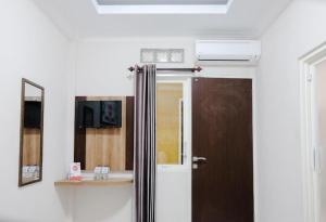 a bathroom with a door with a mirror and a sink at Noura Guest House Syariah in Malang +50 photos