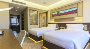 a hotel room with two beds and a desk and a table at Lavande Hotel Tianjin Binhia Yujiabao Finance Center Branch in Binhai +160 photos