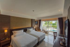 a hotel room with two beds and a television at Sthala, A Tribute Portfolio Hotel, Ubud Bali in Ubud