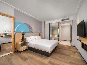 pokój hotelowy z łóżkiem i telewizorem w obiekcie City Comfort Inn Dongguan Humen Wanda High-speed Railway Station Beizha w mieście Dongguan