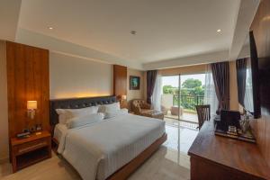 a hotel room with a bed and a television at Sthala, A Tribute Portfolio Hotel, Ubud Bali in Ubud