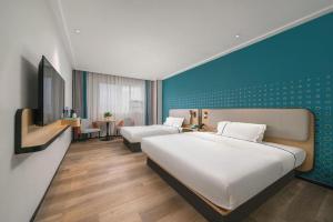 sypialnia z 2 łóżkami i niebieską ścianą w obiekcie City Comfort Inn Dongguan Humen Wanda High-speed Railway Station Beizha w mieście Dongguan +235 zdjęć