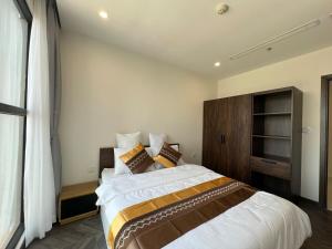 a bedroom with a large bed in a room at VINHOMES GRAND PARK Chillin Home 1BR Best View in Long Bình +2 photos