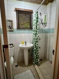 a bathroom with a sink and a shower curtain at Ticao Altamar Boutique Resort in Tahiran