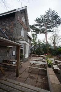 un grupo de mesas de picnic frente a un edificio en The Heights Bunkhouse en Llanberis