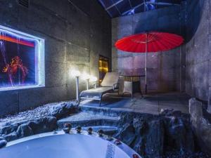 a bathroom with a tub and a red umbrella at Qingdao Hengbo Hotel in Qingdao