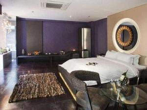 a bedroom with a bed and a table and a mirror at Qingdao Hengbo Hotel in Qingdao