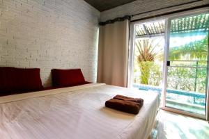 a bedroom with a white bed with a large window at The State Resort in Ban Wat Phrik +124 photos