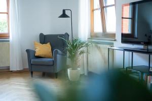 a living room with a chair and a potted plant at Ferienwohnung auf Biohof Gutso in Gaildorf