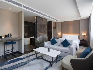 a living room with a bed and a couch and a table at Zhonghao Boutique Hotel Dalang Business Center in Tiantangwei +273 photos