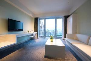 a living room with a couch and a tv at Oasis O.City Hotel in Shenzhen
