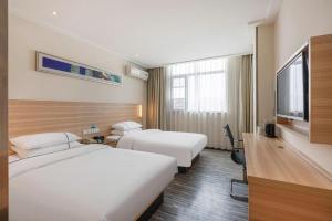 襄阳City Comfort Inn Xiangyang Railway Station的一间有两张床和一台平板电视的酒店房间